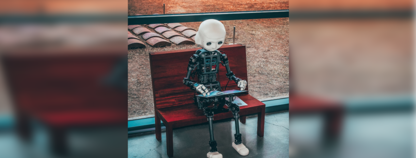 Foto zeigt Roboter auf einer Bank sitzend und lesend.