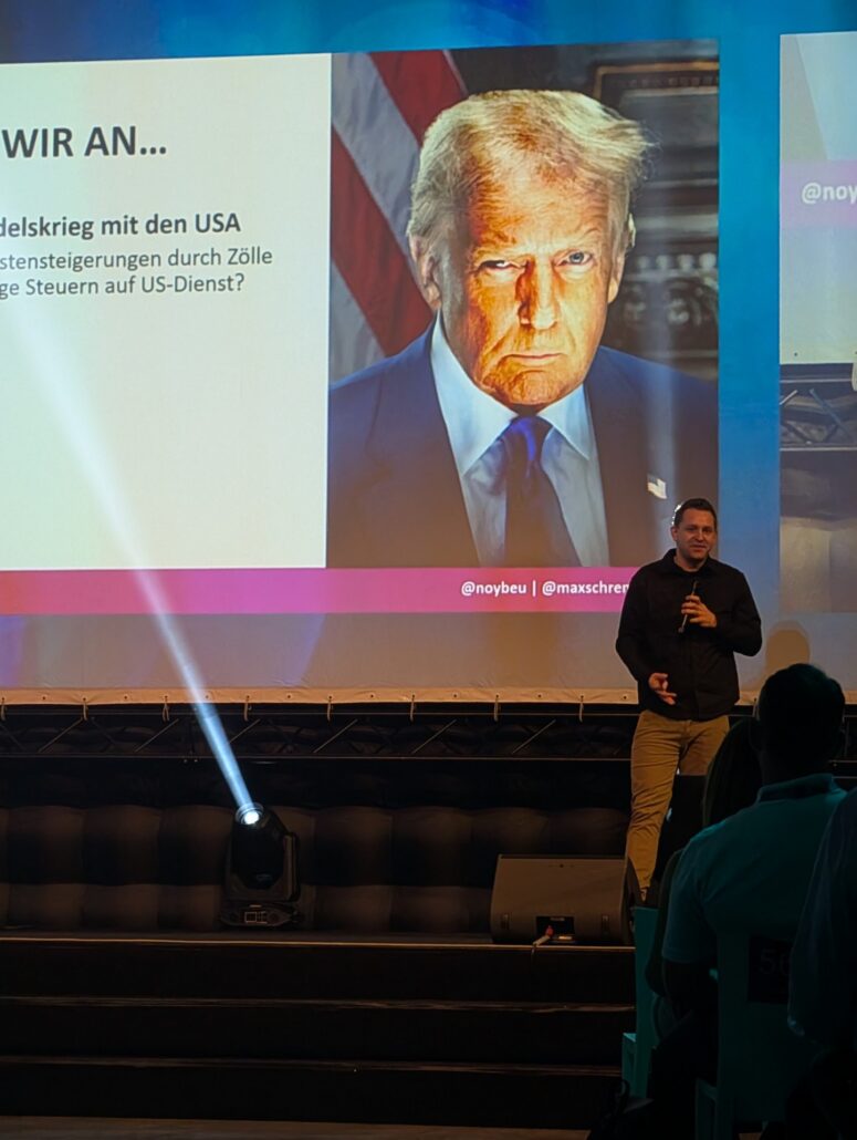 Datenschützer Max Schrems vor einem projizierten Porträt von Donald Trump